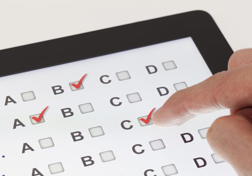 Finger clicking on a tablet with multiple-choice questions